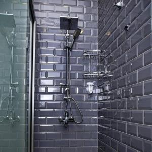 舍基Central Hostel的带淋浴的浴室,浴室设有砖墙
