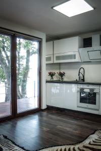 ChlʼabaGolden Beach Apartment的厨房配有白色橱柜和滑动玻璃门