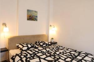 贝尔格莱德Belgrade Center Apartment Nusiceva的卧室配有黑色和白色的床和2个枕头