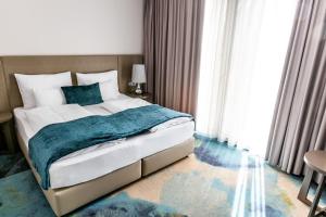 菲拉赫Hotel Seven的一间卧室配有一张带蓝色毯子的大床