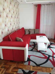 索科矿泉村Lux Apartman Ristić 2的客厅配有红色的沙发和桌子