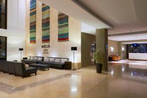 圣玛丽亚Melia Dunas Beach Resort & Spa - All Inclusive的酒店大堂,设有长沙发和墙上的标志