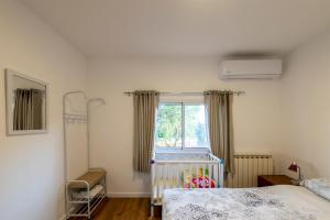 Odemאירוח הר אודם的一间卧室设有一张婴儿床和一扇窗户。