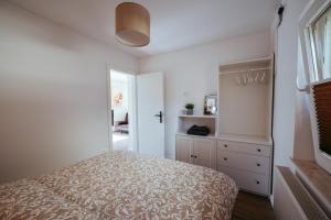 布莱德Apartment Oddih with terrace and private SAUNA的一间白色卧室,配有一张床和一个梳妆台