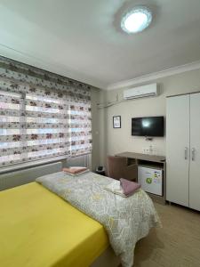 巴勒克埃西尔TEKİNLER OTEL的一间卧室设有黄色的床和窗户。