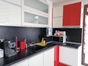 布尔加斯White home-apartament的厨房配有红色和白色的橱柜和水槽