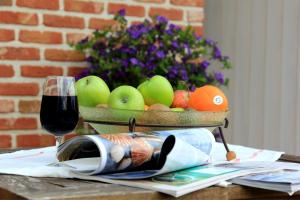 伊普尔B&B Laurus的桌上的水果篮和一杯葡萄酒