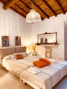 拉蒂纳Casette rosse nel borgo medievale di Fossanova的配有吊灯的客房内一张大白色的床