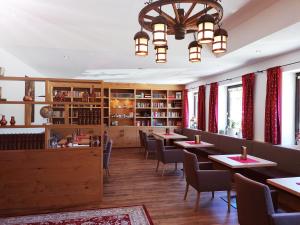 洛伊塔施迪罗勒霍夫酒店的一间带桌椅和吊灯的用餐室