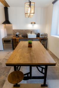 阿姆博斯l'Atelier du menuisier的厨房里设有一张大木桌和柜台