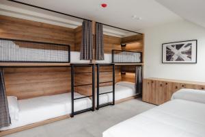 毕尔巴鄂LATROUPE La Granja的宿舍间设有两张双层床,配有木墙