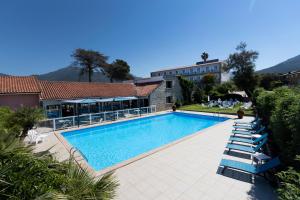 普罗普里亚诺奥库迪斯奥雷酒店的一座带躺椅的游泳池和一座建筑