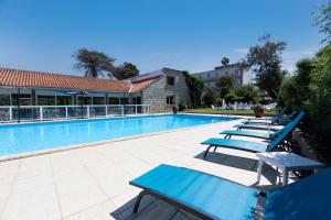 普罗普里亚诺奥库迪斯奥雷酒店的游泳池旁的一排躺椅