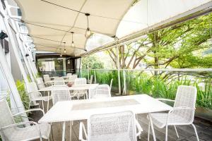 三宝垄Andelir Hotel Simpang Lima Semarang的庭院里一排白色的桌椅