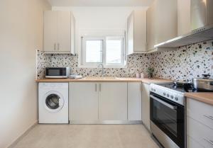 蒂加基Stella's Holiday House的白色的厨房配有洗衣机和烘干机