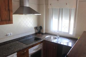 科尼尔-德拉弗龙特拉Apartamento San José Obrero的厨房配有水槽、炉灶和窗户。