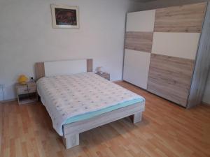 阿伊多夫什契纳Hiša Pepi的一间卧室配有一张床,铺有木地板