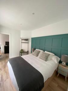 桑坦德Apartamentos Cañalío的一间卧室配有一张大床和绿色床头板