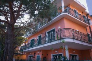 蒙特罗索阿尔马雷Villa degli Argentieri的一座橙色和白色的建筑,设有阳台