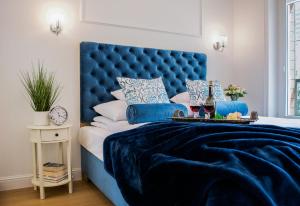 华沙Warsaw Seasons by Alluxe Boutique Apartments的卧室内的蓝色床头板