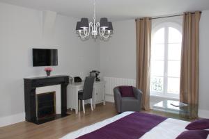 Trie-Château拉佛里庄园旅馆的一间卧室配有一张床、一张桌子和一把椅子