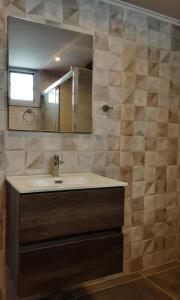 PóndiMaistros Seafront Apartment的一间带水槽和镜子的浴室