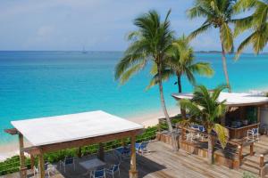 Creek VillageDeluxe Sea View Villas at Paradise Island Beach Club Resort的棕榈树和海洋海滩上的度假村