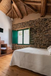 CoañaApartamentos Rurales Casa Llongo的一间卧室设有砖墙和一张床