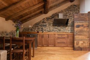 CoañaApartamentos Rurales Casa Llongo的厨房配有木制橱柜和石墙