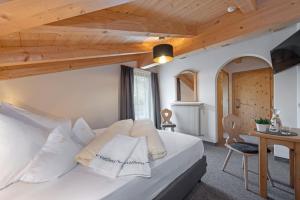布列瑟农Hotel Torgglerhof的卧室配有一张白色大床和木制天花板