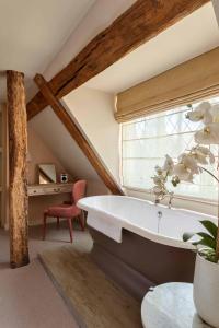 坎特伯雷坎特伯雷的福斯塔夫酒店的阁楼浴室设有浴缸和窗户。