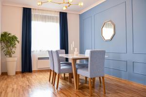 兹拉蒂博尔NIDEHO Estate Apartmani的一间拥有蓝色墙壁和桌椅的用餐室