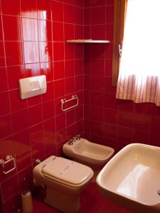 马达莱纳加里波第酒店的红色瓷砖浴室设有卫生间和水槽