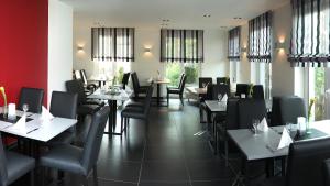 特里尔泽波斯特酒店的用餐室设有桌椅和窗户。