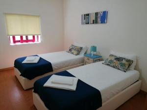 加亚新城Portus Ribeira House的客房设有两张床和一张带窗户的桌子。