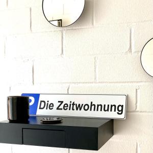 美因河畔霍海姆Die Zeitwohnung的墙上的标志,架上装有咖啡杯