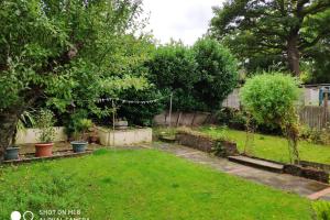 Winchmore HillCozy Entire Bungalow House的花园设有种有树木的草坪和围栏