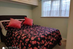 Winchmore HillCozy Entire Bungalow House的一间卧室配有一张带红色枕头的床