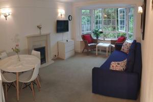 Winchmore HillCozy Entire Bungalow House的客厅配有蓝色的沙发和桌子
