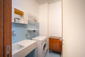 滨海波利尼亚诺WePuglia - Casa sul Ponte的一间带洗衣机和水槽的浴室