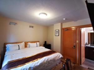 班夫Riverfront Estate Bed&Breakfast Banff的一间卧室设有一张大床和一扇木门