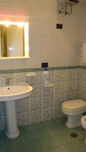 奥斯图尼洛萨马里纳公寓的一间带水槽、卫生间和镜子的浴室