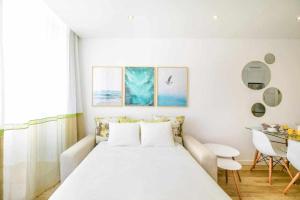 阿玛考德佩拉Timeless Beach II Apartment的白色卧室配有床和桌子