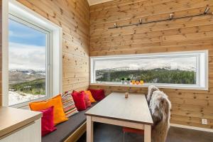 GiljaneTiny mountain cabin with a panoramic view的带桌子和窗户的长凳的房间