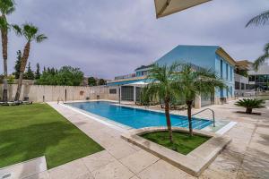 洛尔卡Spa Jardines de Lorca的一座游泳池,旁边是一座棕榈树