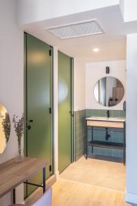 布鲁塞尔LATROUPE Grand Place Hostel的浴室设有绿门、水槽和镜子