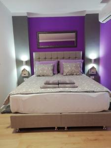 萨格勒布Apartment Mavero-Free Private Parking的一间卧室设有一张紫色墙壁的大床