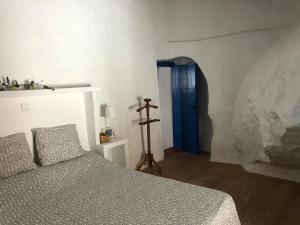 AlmogíaCasa rural en pueblo blanco的一间卧室配有一张床和一个蓝色的门