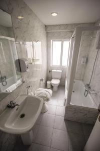 维戈维哥广场酒店的一间带水槽、浴缸和卫生间的浴室