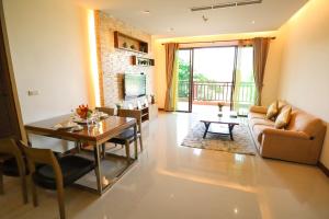 芭堤雅市中心Pattaya City Resort by Harmony的客厅配有桌子和沙发
